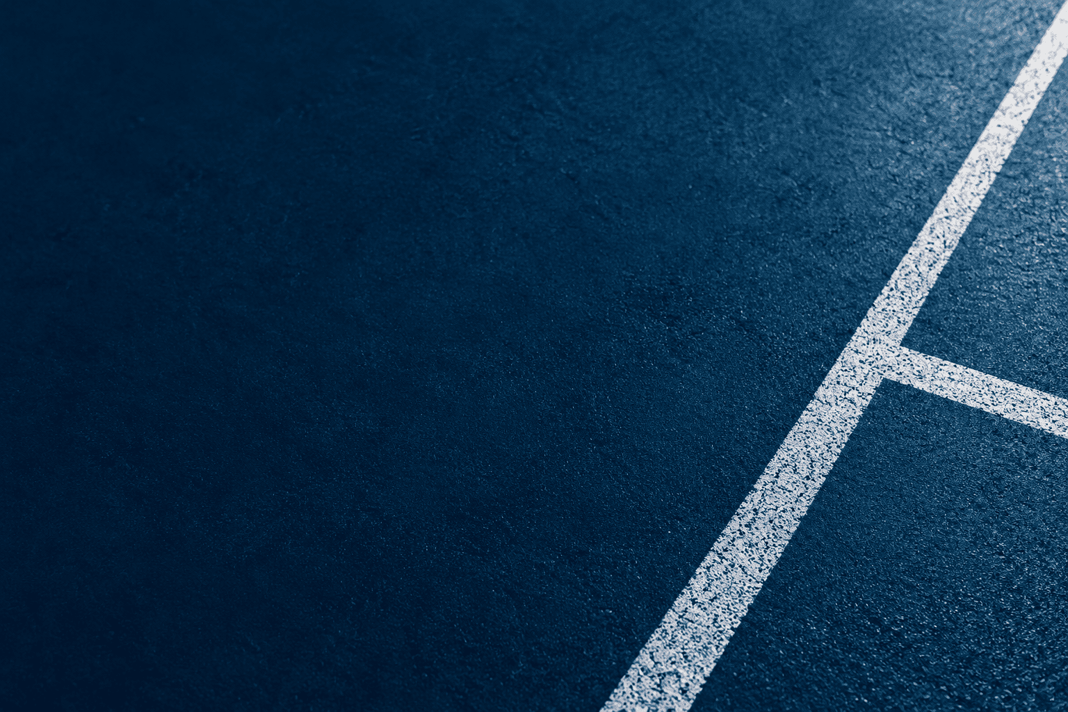 White road marking forming a corner on dark asphalt